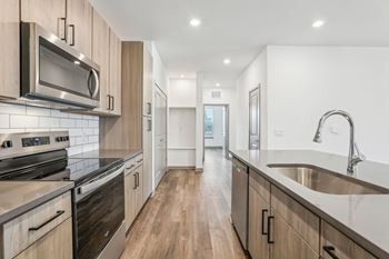 A modern kitchen with wooden cabinets and stainless steel appliances. at The Junction at Rockledge Apartments, Rockledge, FL, 32955